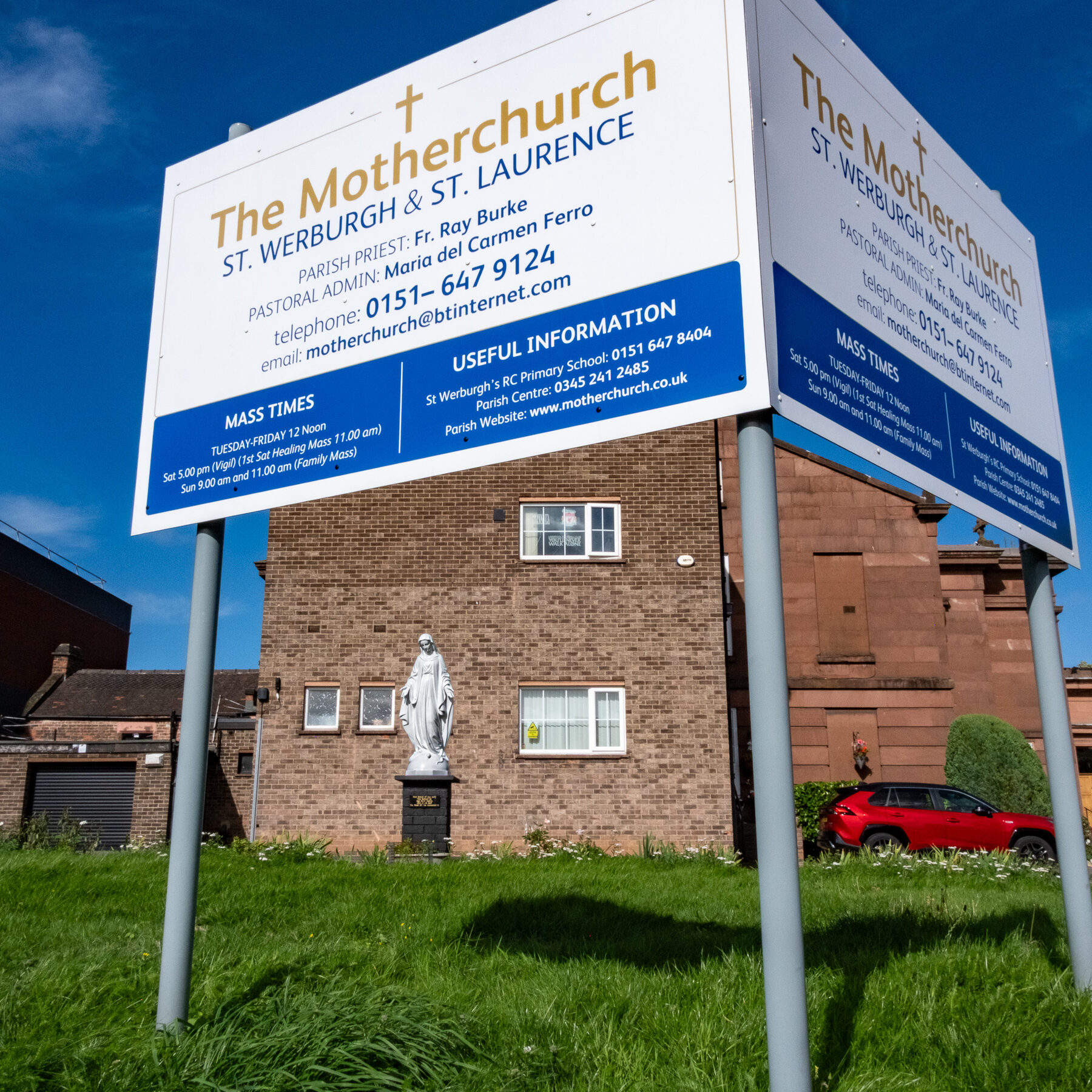 Parish notice board and statue outside flats