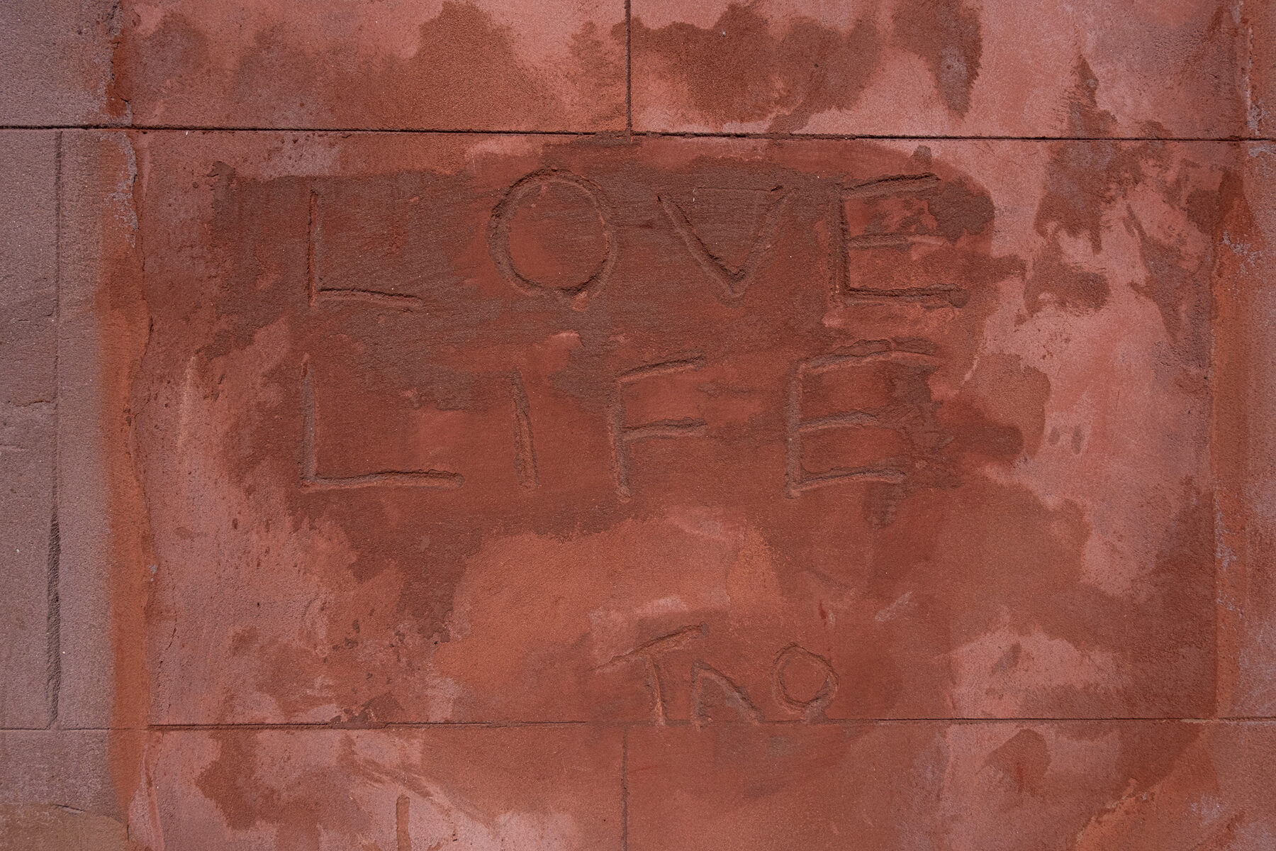 LOVE LIFE carved into red sandstone