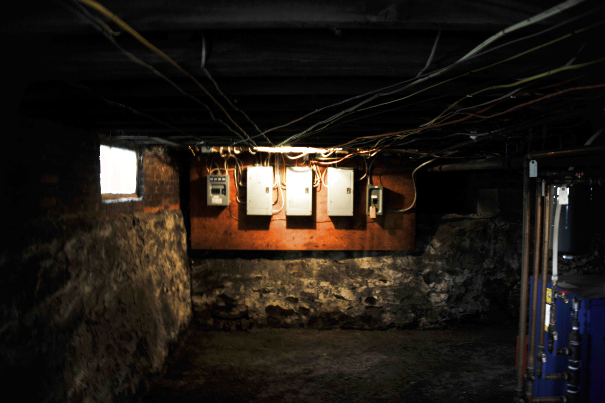 Electrical panels mounted on the old stone cellar wall
