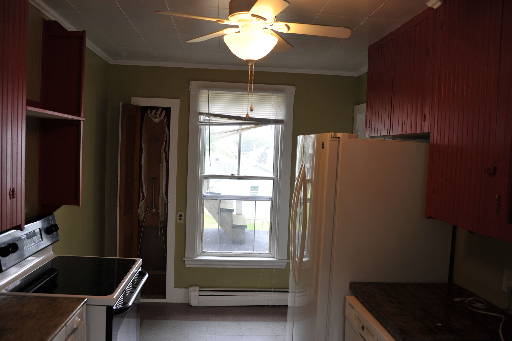 The kitchen in afternoon light with fan and fridge